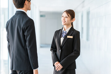 Fototapeta premium Young Asian businessmen in suits having a conversation in an office corridor