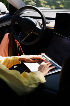 Hands Typing Working on Laptop in Modern Car