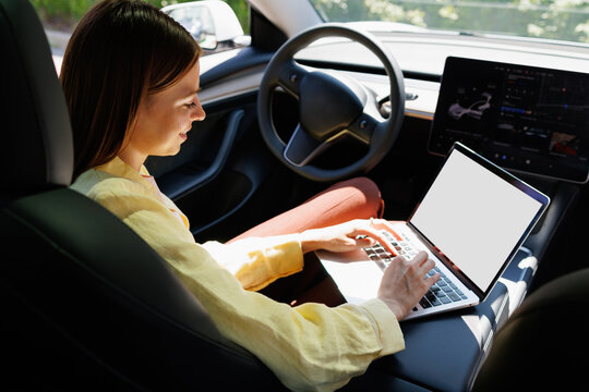 Woman Working in Car with Blank Laptop Screen Mockup