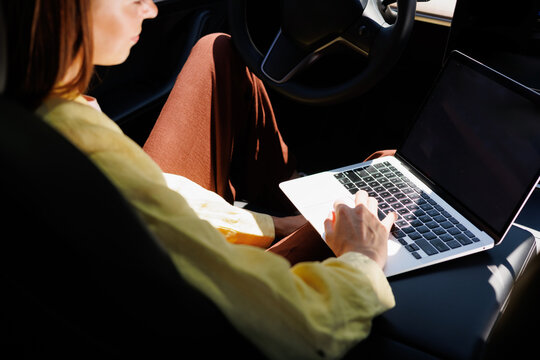 Woman Working on Laptop Inside Car