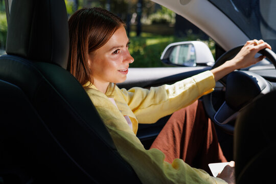 Woman Smiling While Driving Modern Car