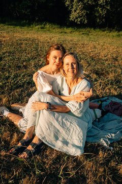 Two Women Enjoying a Sunny Afternoon in a Grassy Field