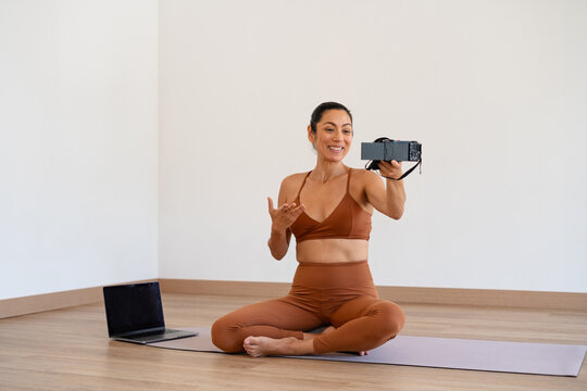 Yoga Instructor Streaming a Virtual Class in a Bright Studio