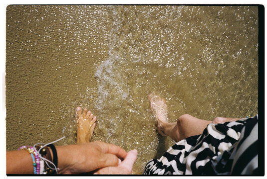 Mother and daughter Holding Hands in Shallow Seawater