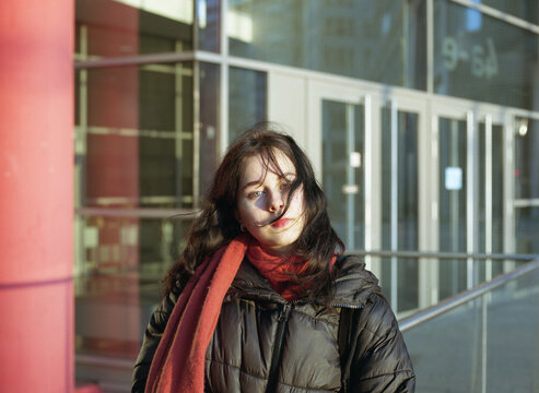 Windblown woman with red scarf in golden winter light