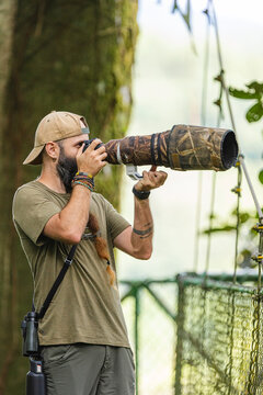 Photographer aiming with camouflaged telephoto lens