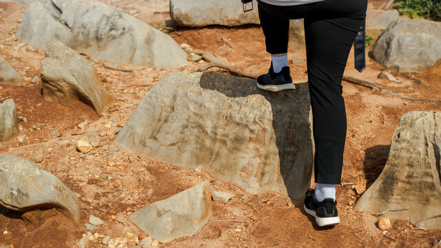 Woman steps on a stone during outdoor walk