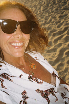 Mature woman beach selfie, golden light