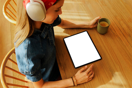 Woman using digital tablet with blank screen at home
