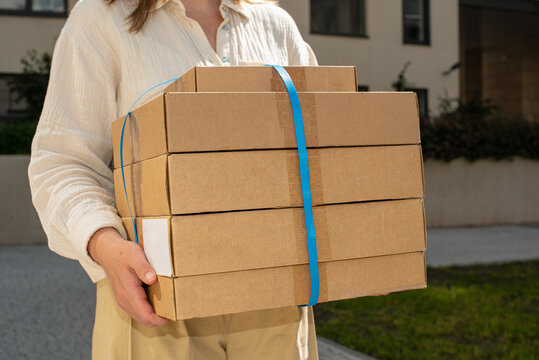 Delivery person carries multiple packages in a residential area