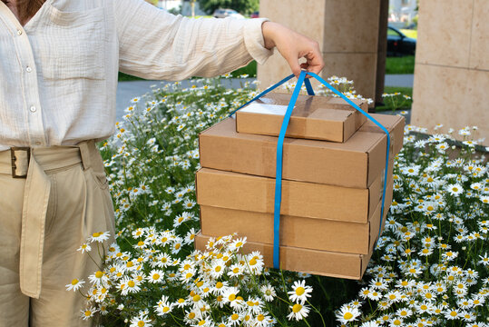 Delivery boxes held above blooming flowers in urban setting