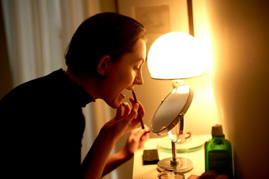 Applying Lipstick While Preparing for an Evening Out