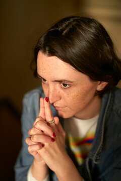 Young Woman Deep in Thought With Finger on Lips During Golden Hour