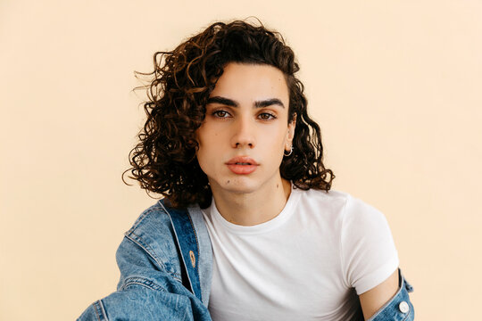 Confident queer man with curly hair