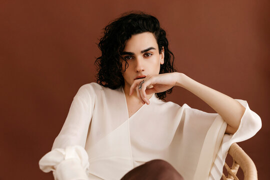 Queer man posing wit hand on mouth