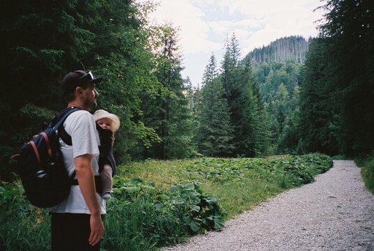 Young man with baby in a sling