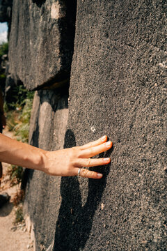 Touching Ancient Stone Walls at an Archaeological Site in Sunlight
