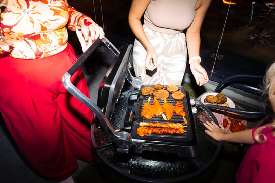 Friends grilling food at a balcony night party
