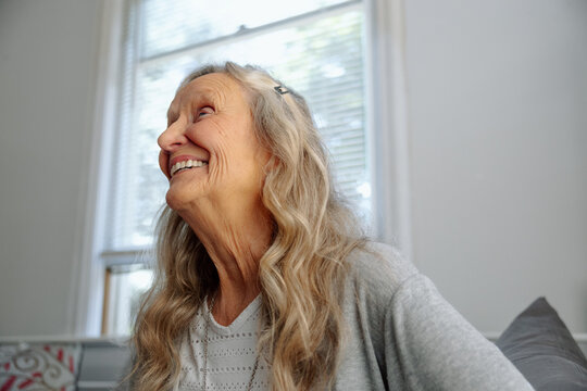 Smiling elderly woman in a candid moment sitting by a window