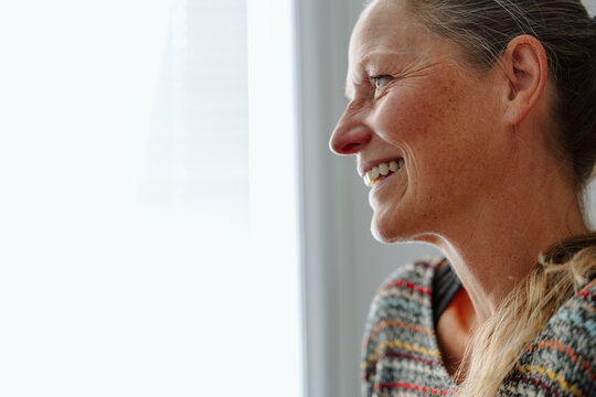 Candid portrait of a woman smiling in natural indoor light