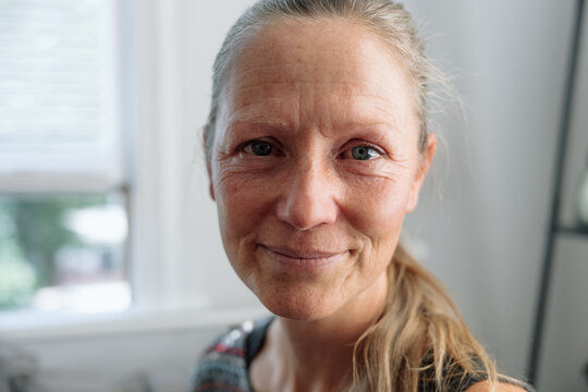 Close-up portrait of a teary woman in a bright room