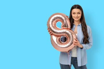 Young woman holds a balloon shaped like the number eight