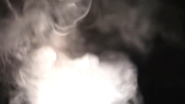 Ethereal white smoke billowing against a dark background, creating a mysterious atmosphere with soft lighting and a sense of intrigue.