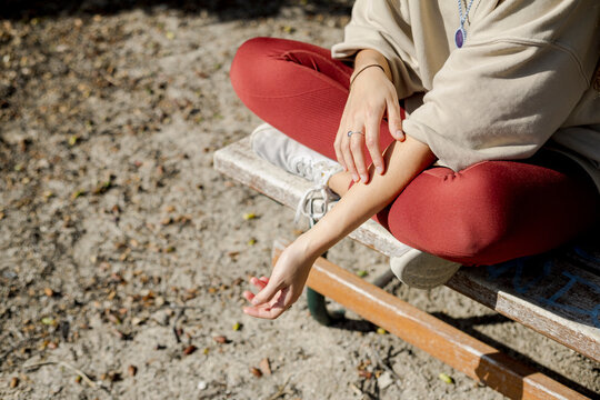 Woman touching her arm outdoors