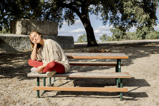 Woman resting on bench outdoors