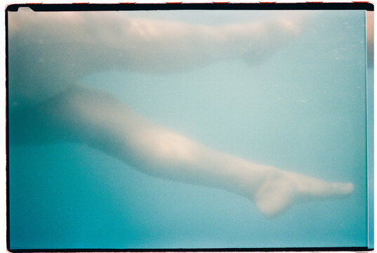 Female legs floating gently underwater