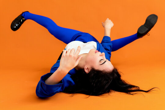 Woman posing on floor, wearing colorful fashion outfit