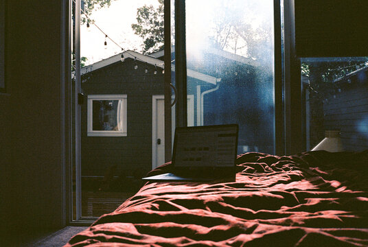 Laptop on the bed on sunny afternoon, shot on film