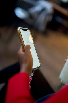Person Holding Smartphone While Seated in a Casual Setting