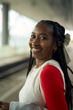 Young Woman Smiling at Train Station During Daylight Hours