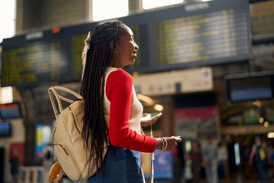 Young Woman With Backpack Waiting at Busy Train Station