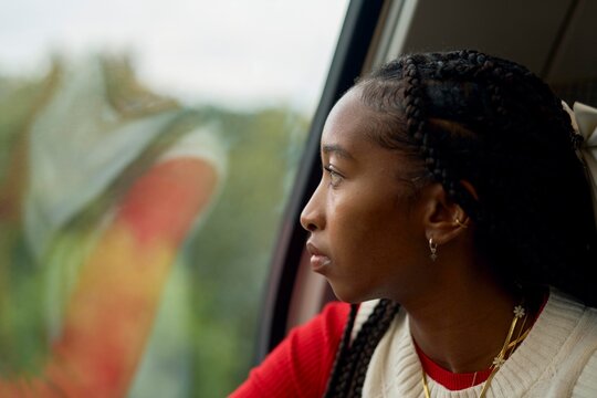Young Woman Gazing out of Train Window During Travel