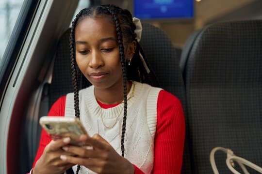 Young Woman Engaged in Texting While Sitting on a Train
