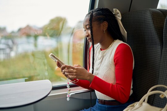 Woman Using Smartphone While Traveling on a Train