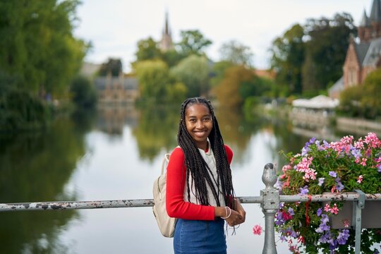Young Girl Standing by a River With Colorful Flowers in Autumn