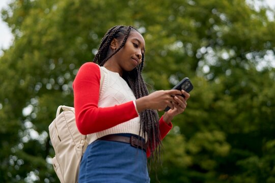 Enjoying a Moment Outdoors While Checking Messages on a Phone