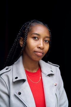 Natural Portrait of a Confident Young Woman Amidst a Dark Backdrop