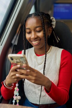Young Woman Enjoying Her Time on a Train While Using Her Smartphone
