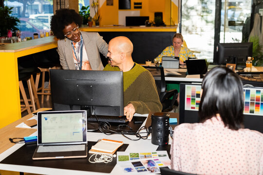 Colleagues joking and laughing at workplace
