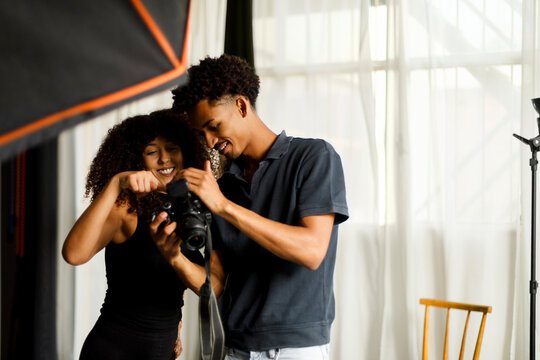 Two Friends Reviewing Photos in a Bright Studio Setting