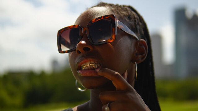 Young woman showing off grillz on her teeth
