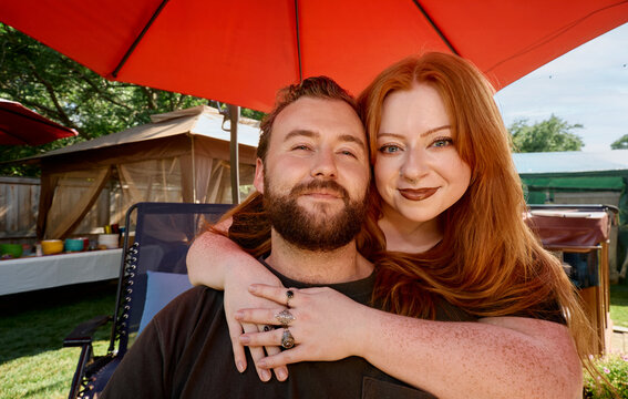 Couple posing together under red umbrella