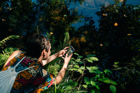 Exploring Nature With a Smartphone Near a Tranquil Pond