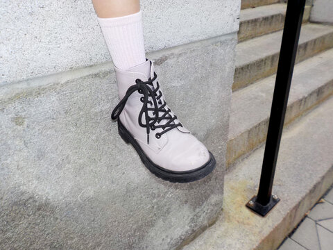 Pink boot, pink socks, on a stone step