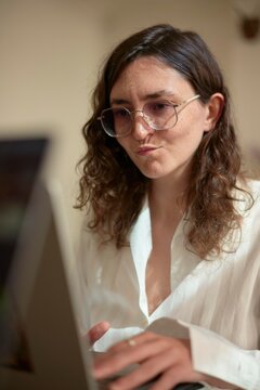 Woman Working on a Laptop in a Cozy Indoor Setting