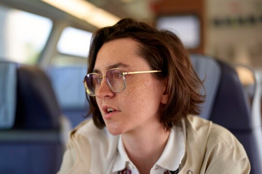 Individual in Train Cabin Engaging in Conversation During Travel